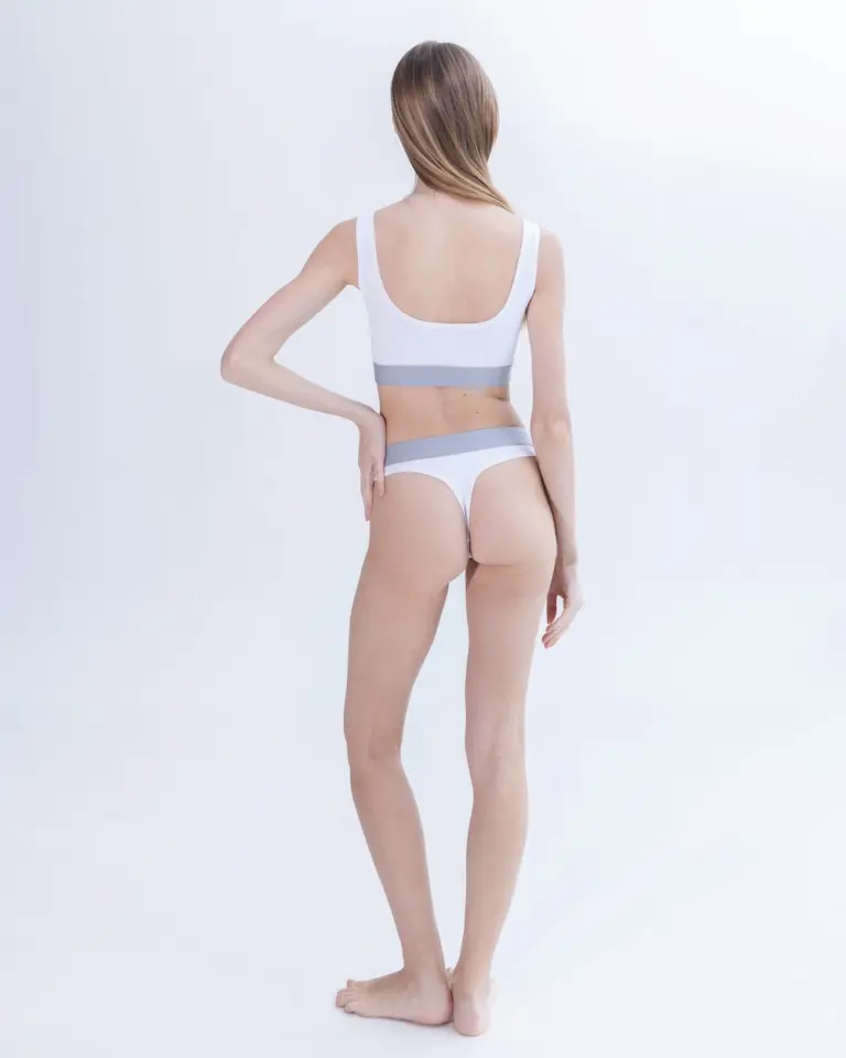 Жіночі білі стрінги з бавовни Intelligent Organism на моделі, вигляд ззаду