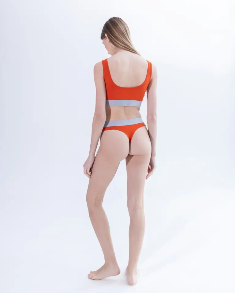 Жіночі помаранчеві стрінги з бавовни Intelligent Organism на моделі, вигляд ззаду